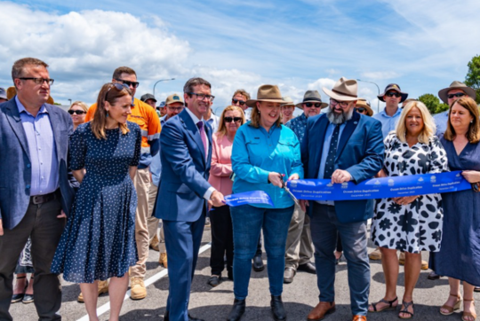 man and woman standing infront of store with open sign